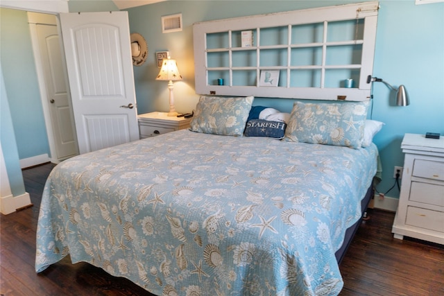 bedroom with visible vents, baseboards, and wood finished floors