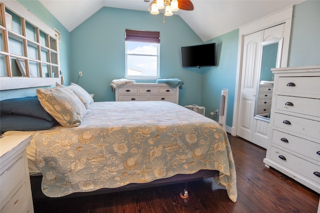 bedroom with a closet, a ceiling fan, vaulted ceiling, and dark wood-style flooring