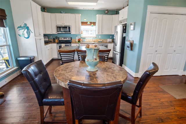 dining area with dark wood-style floors and baseboards