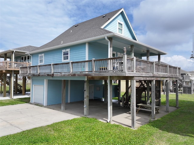 back of property with a shingled roof, a yard, stairway, and a wooden deck