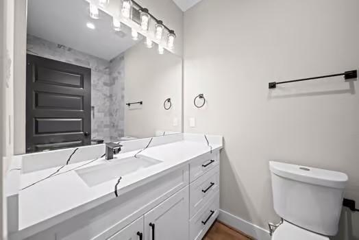 bathroom with vanity, toilet, and baseboards