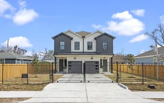 view of front of home with a garage, a fenced front yard, a gate, and concrete driveway