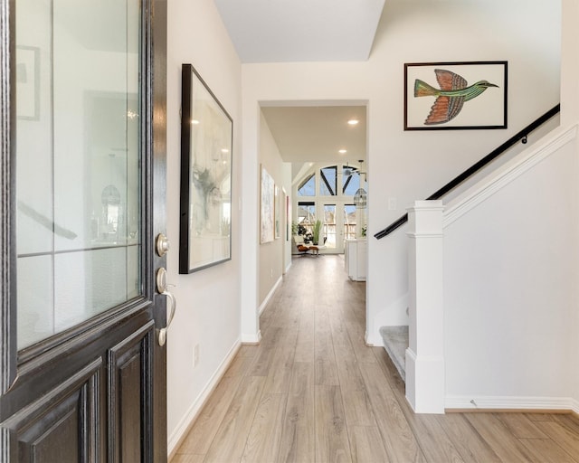 entrance foyer with recessed lighting, light wood-type flooring, stairs, and baseboards