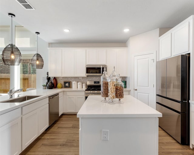 kitchen with light wood finished floors, visible vents, appliances with stainless steel finishes, and a sink