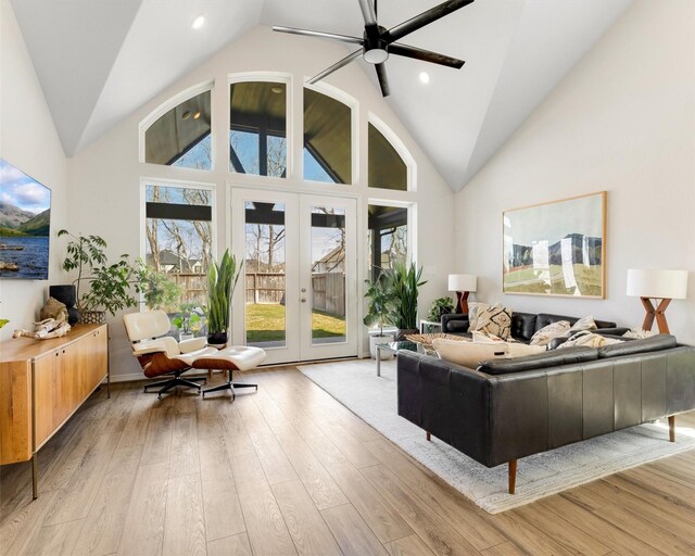 living area featuring light wood finished floors, french doors, high vaulted ceiling, and ceiling fan