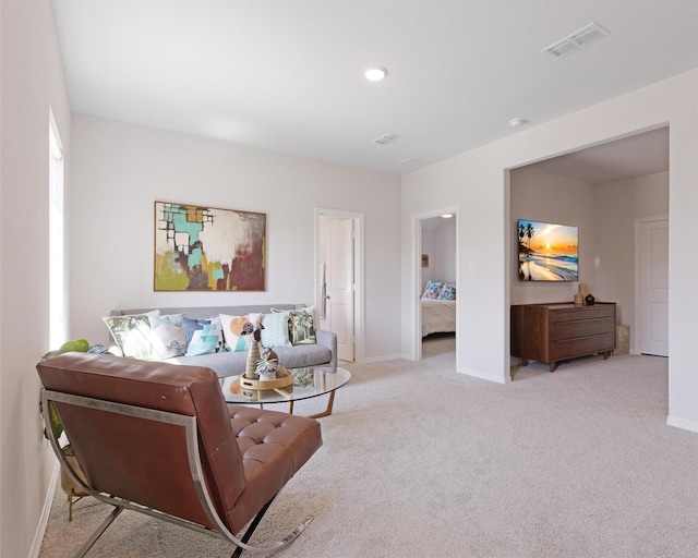 carpeted living area with baseboards and visible vents