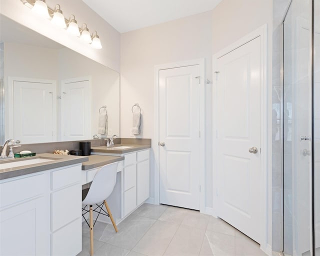 bathroom with a sink, a shower with shower door, double vanity, and tile patterned flooring