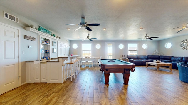 recreation room with a healthy amount of sunlight, visible vents, and light wood-style flooring