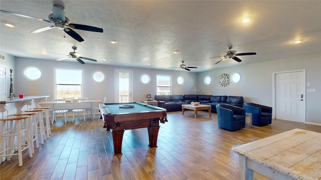 recreation room with a textured ceiling, visible vents, wood finished floors, and pool table