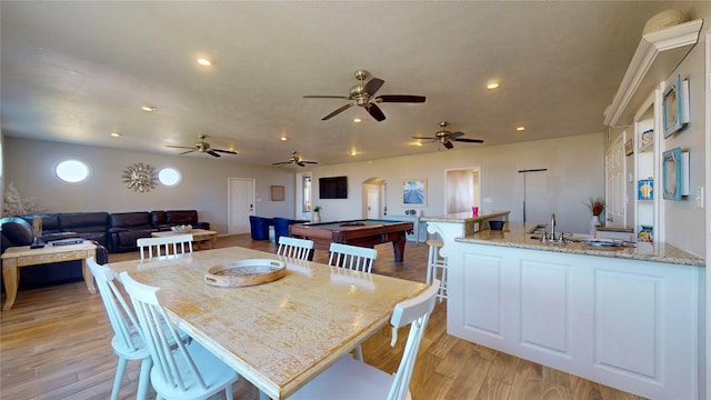 dining space with arched walkways, pool table, light wood-style flooring, and recessed lighting