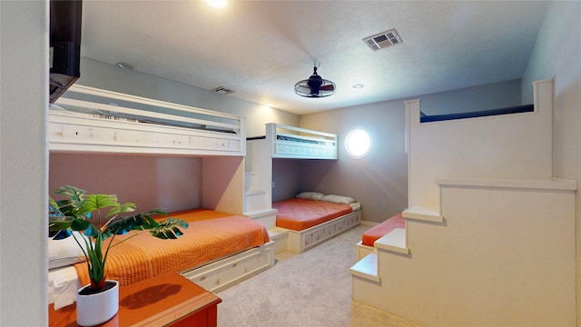 bedroom with a textured ceiling, carpet flooring, and visible vents