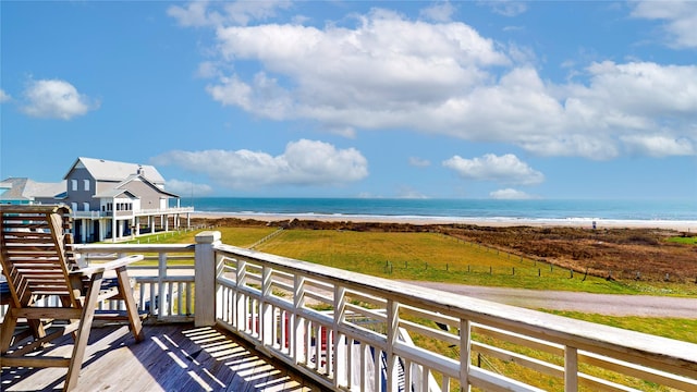 balcony with a water view and a view of the beach