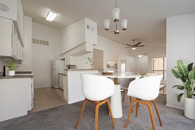 dining room with ceiling fan with notable chandelier, visible vents, light carpet, and light tile patterned floors