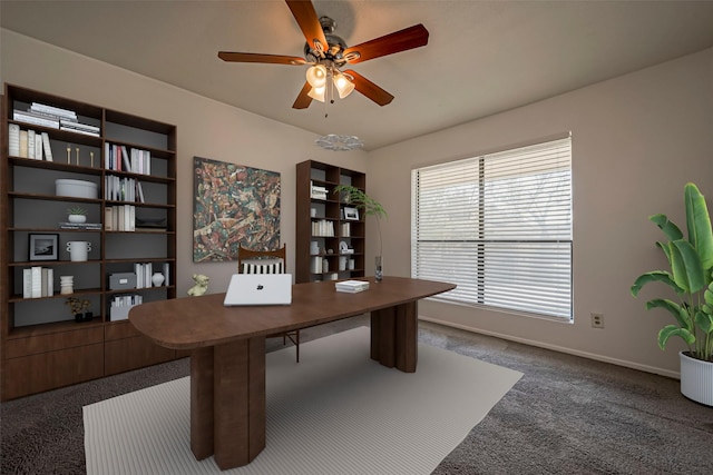 carpeted home office featuring ceiling fan and baseboards