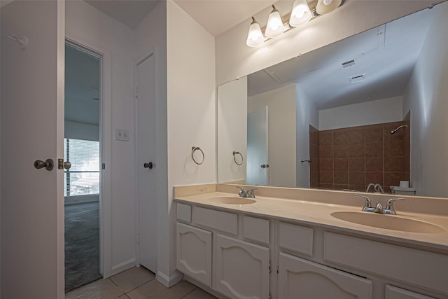 bathroom featuring double vanity, a shower, a sink, and tile patterned floors