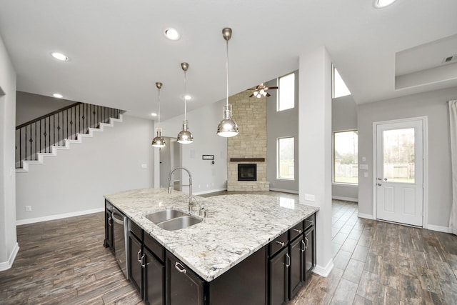 kitchen with open floor plan, a fireplace, a sink, and dark wood-style floors