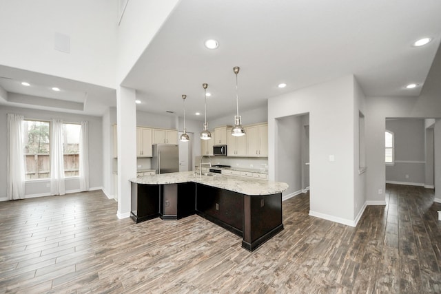 kitchen featuring appliances with stainless steel finishes, light wood-style floors, a large island with sink, and a sink