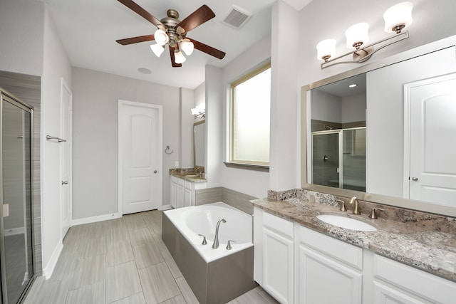 full bath featuring two vanities, a sink, visible vents, a bath, and a stall shower