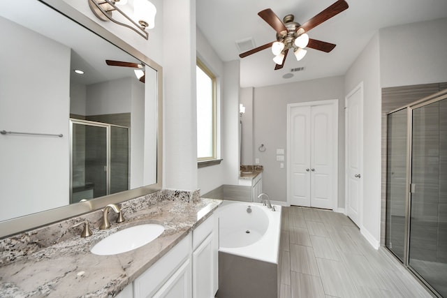 bathroom featuring a stall shower, visible vents, a bath, and vanity