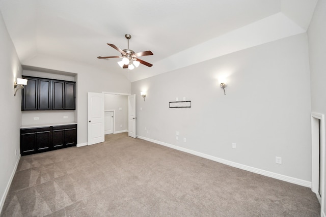 unfurnished living room with a ceiling fan, lofted ceiling, light carpet, and baseboards