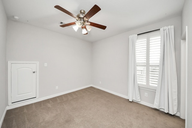 spare room with ceiling fan, visible vents, baseboards, and carpet flooring