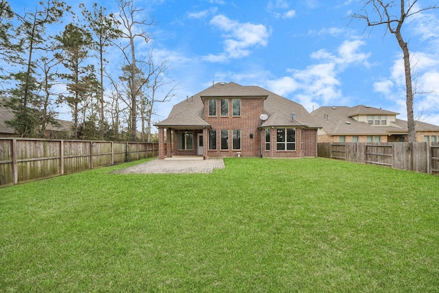 back of property featuring a patio, a yard, a fenced backyard, and brick siding