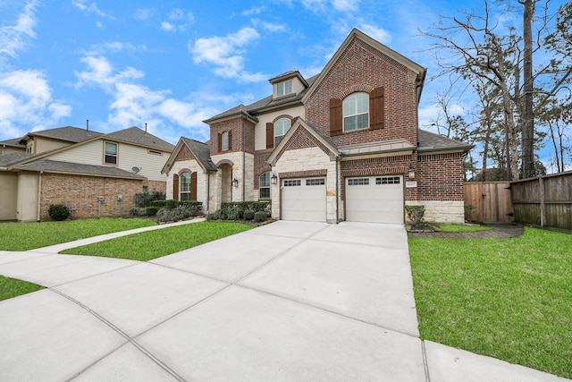 view of front of property featuring a garage, brick siding, a front yard, and fence