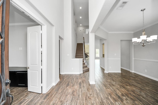 foyer with a notable chandelier, visible vents, stairway, ornamental molding, and wood finished floors