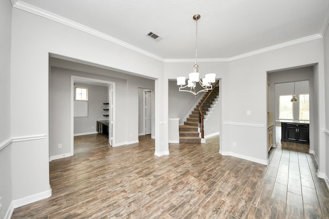 unfurnished dining area with a notable chandelier, visible vents, ornamental molding, wood finished floors, and baseboards