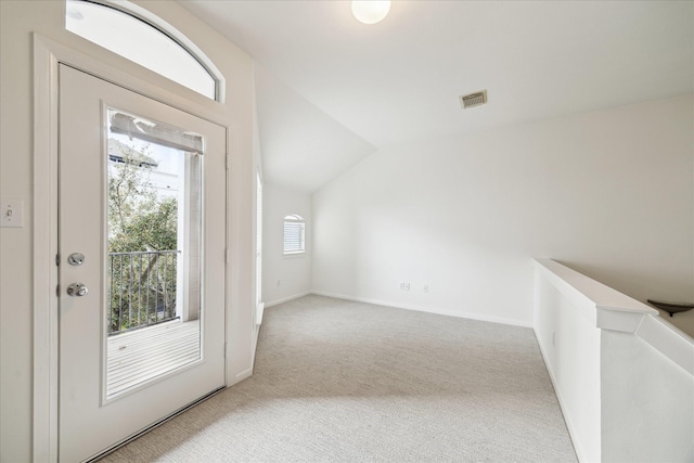 carpeted foyer entrance featuring vaulted ceiling, visible vents, and baseboards