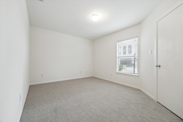 unfurnished room featuring carpet and baseboards