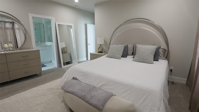 carpeted bedroom featuring a sink, recessed lighting, ensuite bath, and baseboards