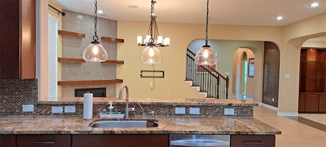 kitchen featuring tasteful backsplash, stone countertops, and a sink