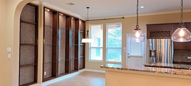 kitchen with light stone counters, dark brown cabinetry, crown molding, stainless steel refrigerator with ice dispenser, and pendant lighting