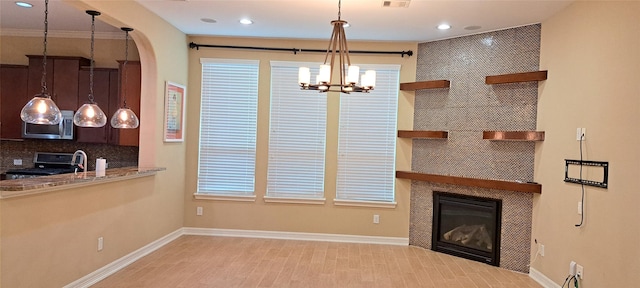 unfurnished living room featuring recessed lighting, a tiled fireplace, and baseboards