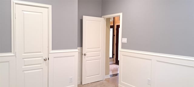 hall featuring a wainscoted wall