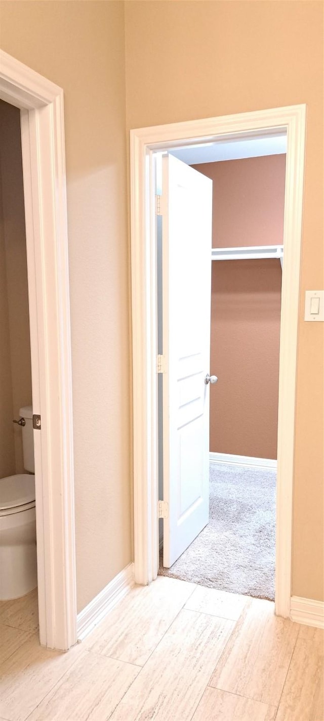bathroom featuring baseboards and toilet