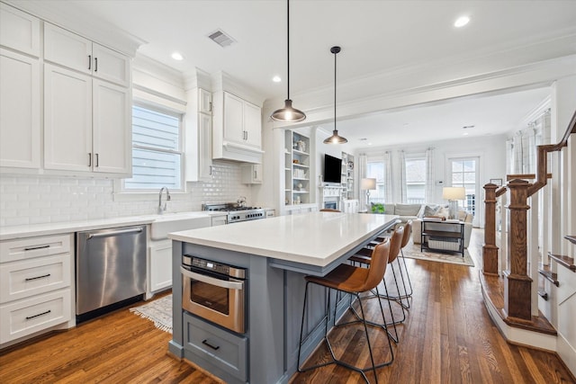 kitchen with visible vents, appliances with stainless steel finishes, open floor plan, light countertops, and gray cabinetry