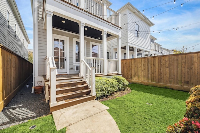 doorway to property featuring a porch, fence, and a balcony