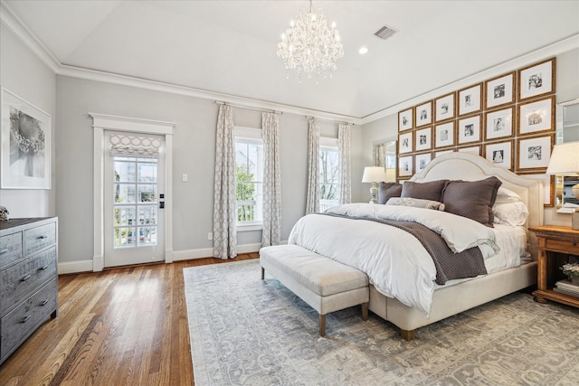 bedroom with visible vents, crown molding, baseboards, and wood finished floors