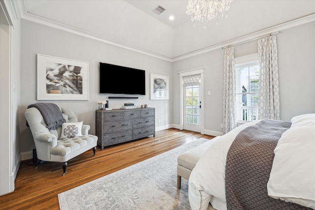 bedroom with access to exterior, visible vents, wood finished floors, and an inviting chandelier