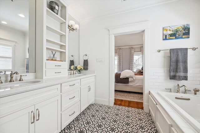 full bathroom with double vanity, a sink, ensuite bath, and a bath