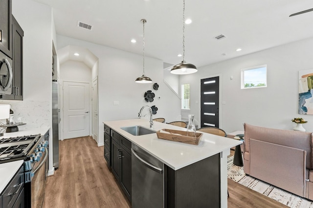 2110 Dewalt St Unit H, Houston, TX 77088 - kitchen featuring stainless steel appliances, a sink, dark cabinets, light countertops, and light wood-type flooring