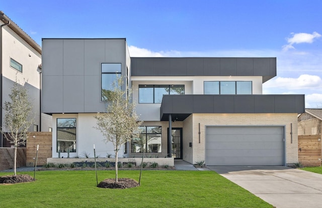 contemporary home featuring driveway, brick siding, fence, a front yard, and stucco siding