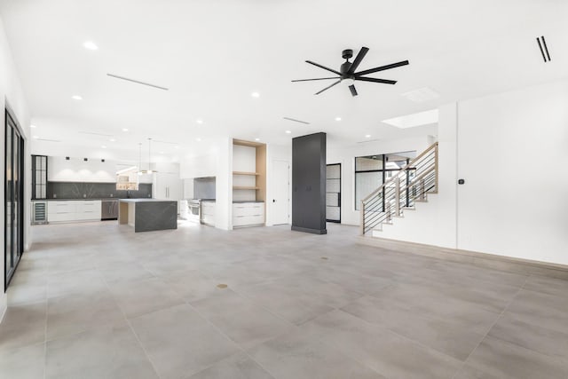 unfurnished living room featuring recessed lighting, visible vents, ceiling fan, and stairs