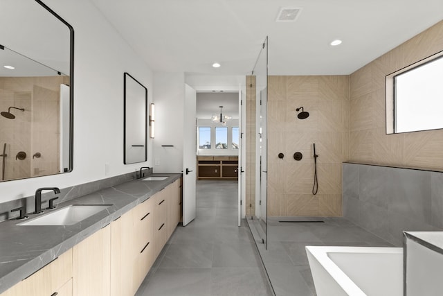 full bath featuring a wealth of natural light, visible vents, walk in shower, and a sink