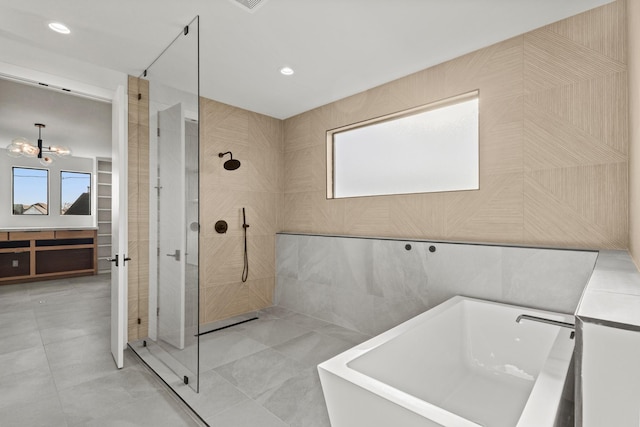 bathroom with recessed lighting, a soaking tub, tile walls, and walk in shower