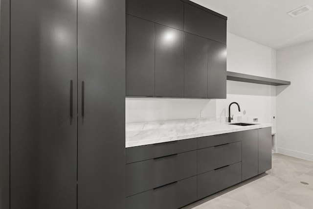 kitchen featuring open shelves, modern cabinets, and a sink