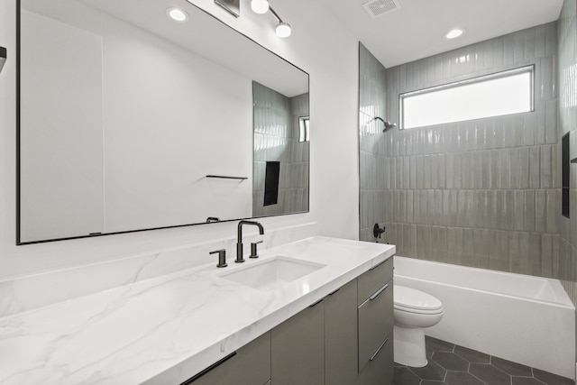 bathroom with shower / tub combination, toilet, visible vents, vanity, and tile patterned floors