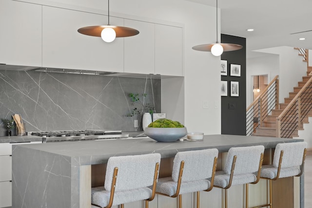 1225 Althea Dr, Houston, TX 77018 - kitchen with modern cabinets, white cabinetry, backsplash, decorative light fixtures, and a kitchen breakfast bar